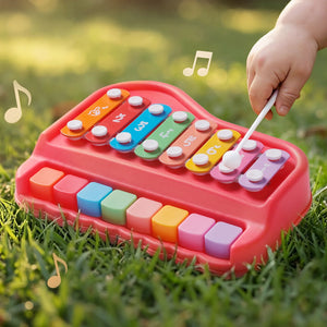 Colorful toy keyboard with child's hand playing on grass